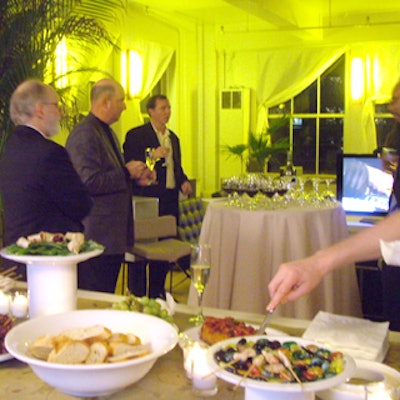 Premier Party Servers catered hors d’oeuvres like baked brie, fruit, and chicken and shrimp skewers on an embroidered organza-clothed table.