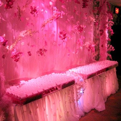 Guests encountered David Beahm’s place-card table as they approached the cocktail and sale area. Draped fabric behind the table was framed by feathers and decorated with delicate glass vials holding orchid blossoms.