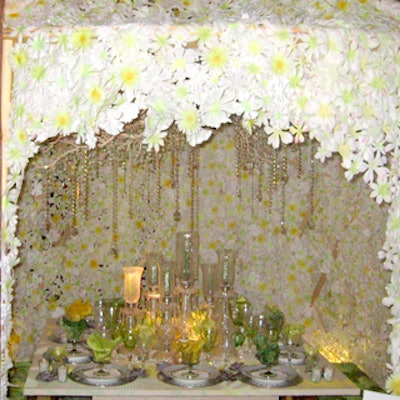 Maria McBride designed a wooden lattice garden structure laced with fabric daisies and a bejeweled driftwood chandelier with hanging glass crystals for the table sponsored by Free People.