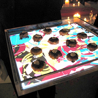 Olivier Cheng Catering and Events’ caterwaiters passed hors d’oeuvres on underlit trays decorated with the pattern taken from Suede's logo.
