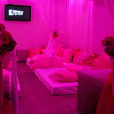 Billowy white fabric tied with pink silk flowers draped the venue’s signature bed-style seating areas.