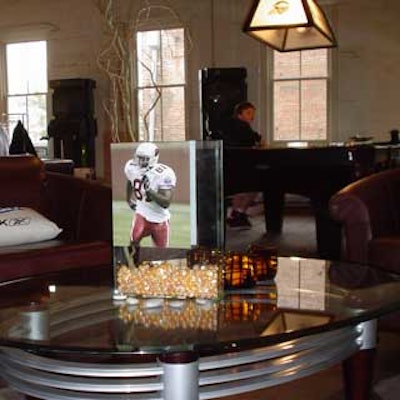 A coffee table at the Reebok Hospitality Suite got topped with an unlikely centerpiece—a square vase full of decorative stones, flowers, and an image of a football player.