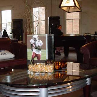 A coffee table at the Reebok Hospitality Suite got topped with an unlikely centerpiece—a square vase full of decorative stones, flowers, and an image of a football player.