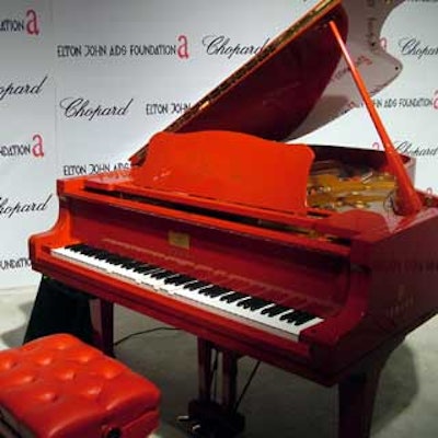 In a live auction, the first two in a series of limited edition Yamaha signature red pianos signed by John sold for $150,000 each.