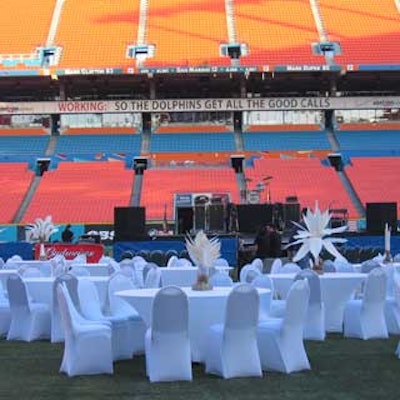 White spandex-covered tables and chairs were set up on the playing field of Dolphins Stadium for the Stadium Managers Association's annual conference.