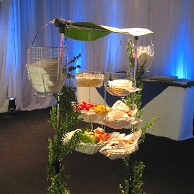 Gourmet Cuisine Full Service Catering provided a vertical veggie station adorned with banana leaves and foliage.