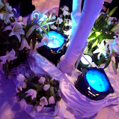 Blue up-lighting from the bases of white birch trees drew attention to the springlike white lilies and tulips clustered there.