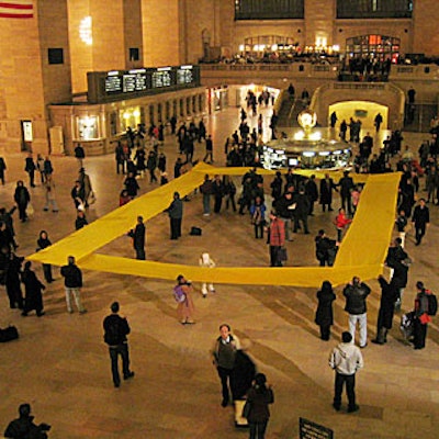 Steve Boyd of Arts for Events choreographed the unfurling of National Geographic's yellow frame trademark on the floor of Grand Central Terminal.