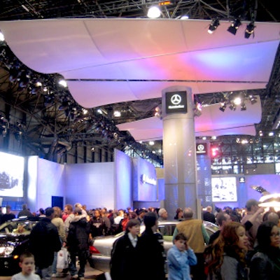 The colorful Mercedes-Benz booth featured all-white walls and undulating white panels suspended from the ceiling. Vibrant, color-shifting lights changed the mood and atmosphere of the booth.