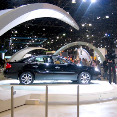 Cadillac’s booth was the curviest of them all: Swooping arms hung over the car platforms, and the Cadillac logo rotated from a silver arch that curved above the information desk. A black marble fountain spurted graceful, arching streams of water.