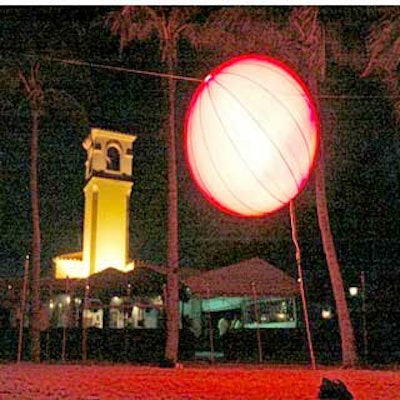 In order to create more ambient lighting, Airstar balloons were covered with red socks and placed over stages on the beach.