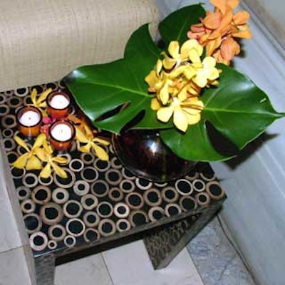 Squat brown cocktail tables featured delicate patterns of gold rings, and held white flowers and votives in brown glass holders.