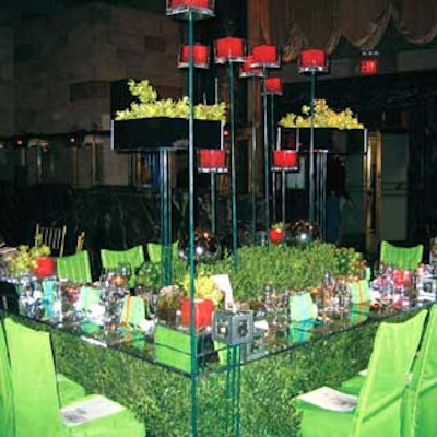 At the Horticultural Society of New York's annual benefit, Susan Edgar put boxwood hedges under a glass-topped table decorated with green napkins wrapped with preppy-colored ribbons, mirrored spheres and boxes, cube-shaped orange candles, and boxy glass vases filled with stones, limes, and pale green orchids. The hedges probably didn't make for comfortable seating for women in dresses, but the odd mix of influences and materials made it one of our favorite designs of the night.