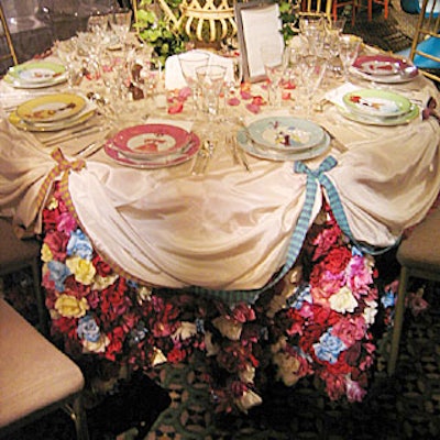 Although the flowers topping Prudence Designs’ table were not as imposing as some of the others, the Christian Lacroix for Christofle china (showing women in period dress) and the tablecloth drew attention. Resembling a ball gown Cinderella might have worn, the table’s top layer of silk taffeta—gathered and embellished with Mokuba ribbons—revealed an underskirt of brightly colored silk roses.