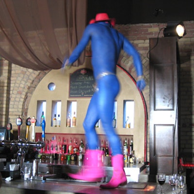 Models painted blue danced atop bars wearing pink cowboy boots, red hats, and not much else.