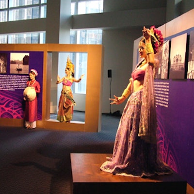 Costumed Thai models posed on platforms in front of signage with information about the new service.