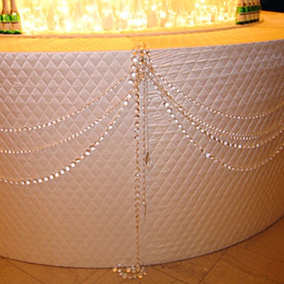 Quilted satin draped with strings of Swarovski crystals covered the base of the champagne flute cake.