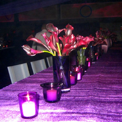Long communal tables topped with votive candles and vases of deep purple calla lilies flanked the central bar.