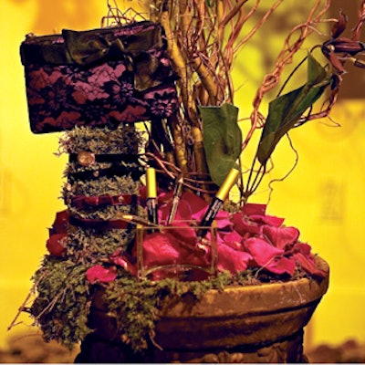 The makeup section featured beautiful red umbrellas hovering over a wooden park bench and moss-covered pedestals that displayed the products and purses from the Mark accessories collection.