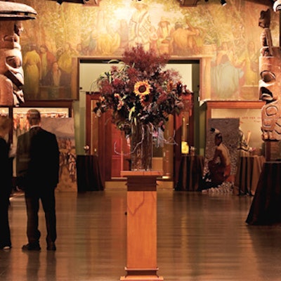 The Hall of Northwest Coast Indians was accented with burgundy cloth-covered cocktail tables, floral arrangements, and blowup photos of scenes from the film.