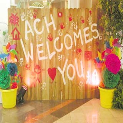 The hospital made a welcome sign using a wooden fence and red and white paint.