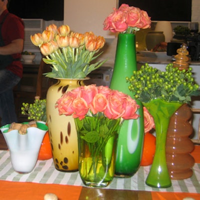 Vases filled with roses and tulips topped them dining room tables laid with green-and-white-striped and bright orange cloths.
