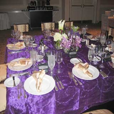 DECO Productions dressed tables with royal purple linens and arrangements of white and purple flowers.