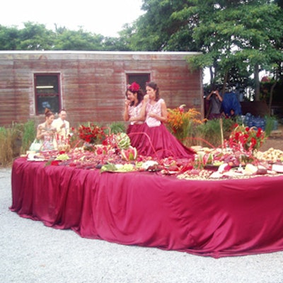 Brazilian artist Paula Gabriela's installation of two live models eating fruit and chanting, 'Alimenta da arte' (Portuguese for 'nourishment for art”) at the center of a table laden with fruit, cheese, and bread doubled as a food station and entertainment at the Watermill Center's summer benefit.