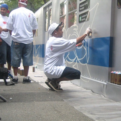 Graffiti artists spray-painted mock subway cars.