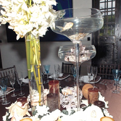 On the tabletops, albino goldfish swam in giant snifter-shaped vases amid seashells and white flowers.