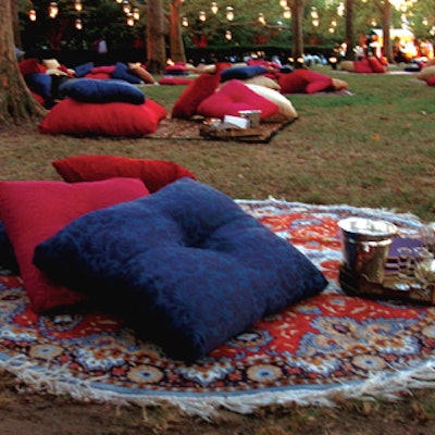 One hundred Persian rugs strewn with cushy pillows, silver trays of caviar, appetizers, and Imperia were scattered around the park. Scores of glass lanterns hung from the treetop canopy to create an ethereal atmosphere.