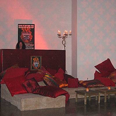 Music emanated from the custom-built DJ booth, upholstered in a red snakeskin material and perched atop a carpeted platform strewn with pillows in vermillion and gold satin and velour.