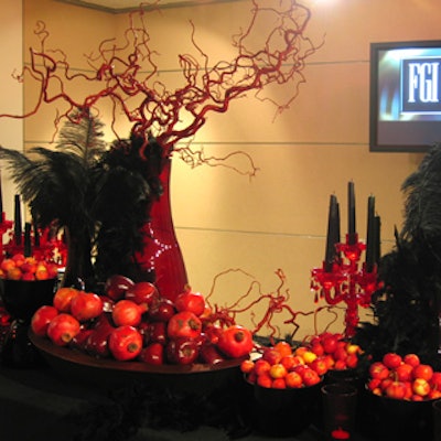 A display of stylized barren red branches, red candelabras, pomegranates, and red apples against a black background, by caterer Gibson & Lyle, helped convey the theme of decadence.