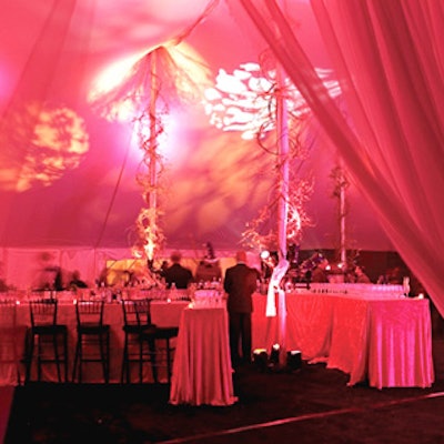 For the cocktail hour that preceded dinner, bittersweet and grapevines wrapped tent poles, and deep magenta and orangey light bathed the space.