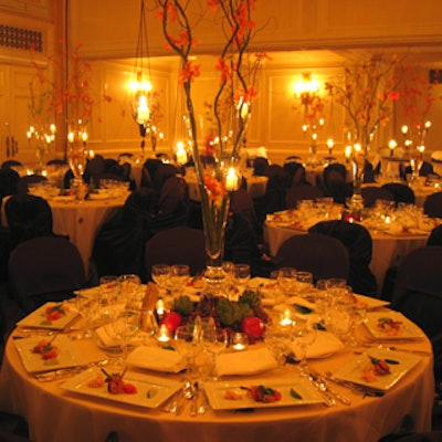 Centrepieces from Forget Me Not featured votive candles hung from branches with budding leaves.