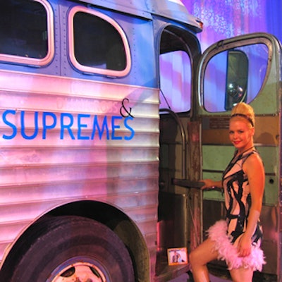 A costumed model from Monarch Events Group posed by a tour bus inscribed 'Diana Ross and the Supremes.'