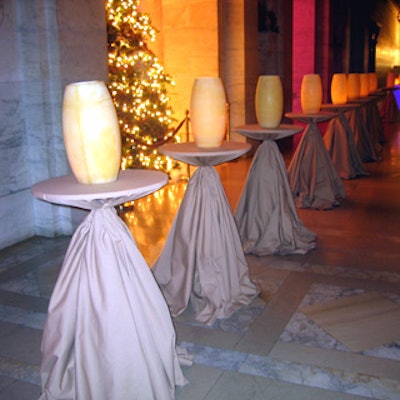 A promenade of suede-wrapped tables topped with tall wax hurricane lanterns achieved a sculptural effect.