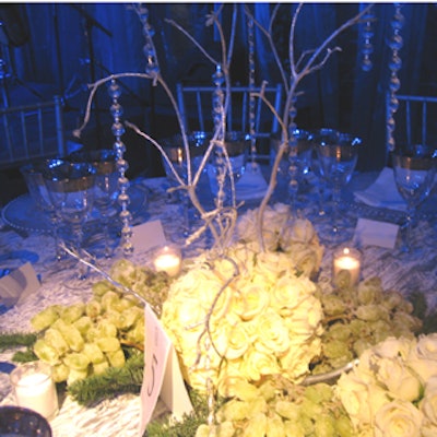 Clusters of white roses and stark branches hung with crystal baubles made up the centerpieces by Karla Conceptual Event Experiences.