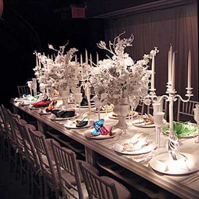 Downstairs was a long dining table set with candelabra, oversize flower arrangements, and full place settings, all painted white by Geoff Howell Studio to set off colorful crystal-encrusted shoes on each plate.