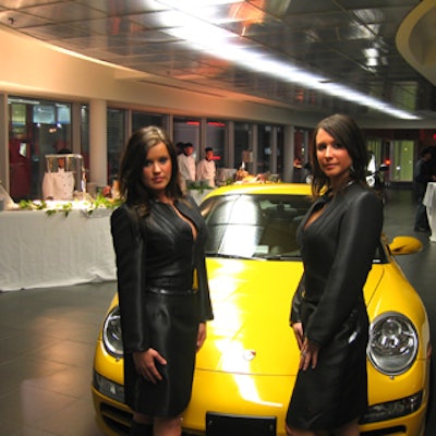 Hostesses in leather outfits trimmed with alligator posed in the Downtown Porsche dealership at the launch of the Porsche Cayman S.