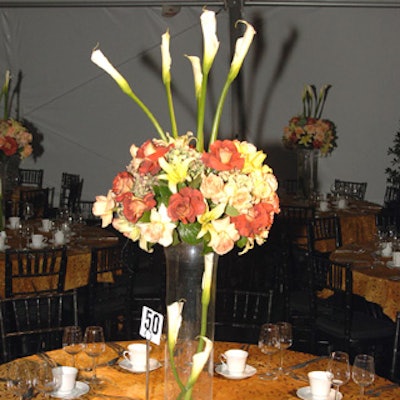 Jewel-tone roses spilled over tall, see-through vases that enclosed sprays of calla lilies.
