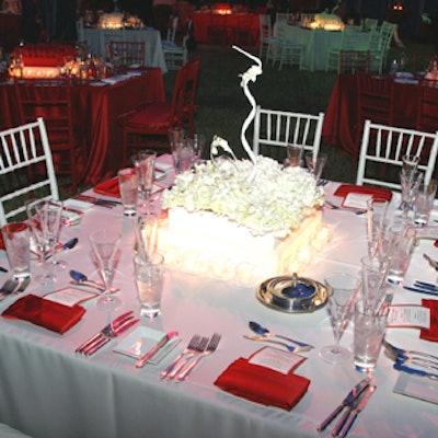 A white triangular table was adorned with a same-shaped floral centerpiece lit from within.