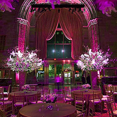 Reaching up to 16 feet tall, the event's floral arrangements by Collage Florals combined white polo roses, Casablanca lilies, amaryllis and pink quince branches with tufts of white ostrich feathers.