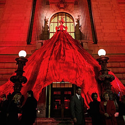 As guests arrived at the library for the American Heart Association's campaign promotion, they found themselves sprinkled with white rose petals by a model dressed in an elaborate silk organza and sheer beaded fabric dress with a 30-foot-long skirt that draped over the entryway of the New York Public Library.
