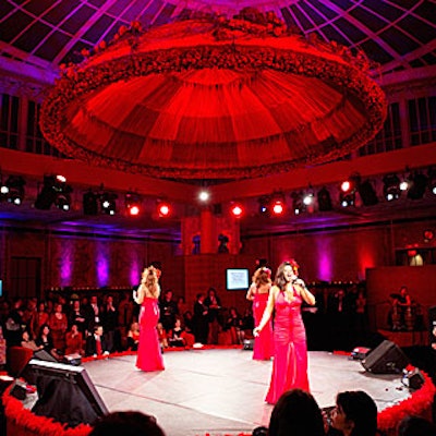 A giant red flower- and-fabric-covered dome constructed with 2,500 rosebuds, aged vines, and hanging amaranthus hung above a circular stage, where the evening's performances took place.