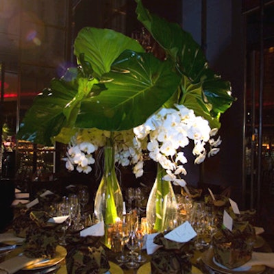 Interior designer Nina Campbell worked with Antony Todd to create an exotic table dominated by enormous elephant ear leaves and white orchids arranged in two teardrop-shaped vases. The tablecloth and gift sacks at each place setting were made of Campbell’s green and bronze silk with brown floral-pattern flock design.