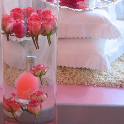 Rosebuds and bottles of Aliz? Rose were suspended in water-filled glass cylinders at the edge of the stage.
