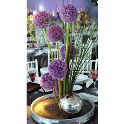 Bruce Sutka of West Palm Beach, Florida-based Sutka Productions mixed lavender, silver, and crystal elements in the different centerpieces at the Rush Philanthropic Arts Foundation's Art for Life event at Russell Simmons's East Hampton home. In an arrangement of allium, tall chives mimicked the flower's long stalks and a silver-colored orb at the base repeated the flower's spherical shape.