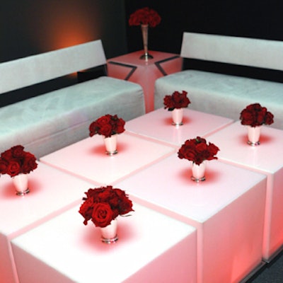 Modern, geometric couches and ottomans were covered in white faux suede, and red lights encased in frosted-plastic cubes cast a soft, flattering glow.
