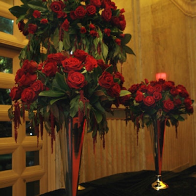 A flower arrangement used 3,000 red roses trailing red tendrils in silver-plated, trumpet-shaped vases in three sizes.